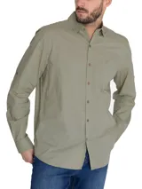 Camisa manga larga color verde oliva, confeccionada en popelina 100% algodón orgánico. Cuenta con cuello camisero, cierre frontal con botones de madera, bolsillo en el pecho con logo bordado y mangas ajustables con botones.
