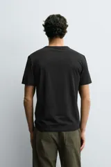 Camiseta de corte ajustado confeccionada en tejido de algodón con elasticidad, cuello redondo y manga corta.