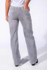 Pantalón de jean gris con apliques de lentejuelas plateadas en forma de cuadrícula.