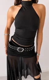 Top negro de cuello alto y diseño sin mangas con corte halter.