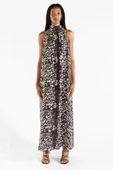 Vestido largo con cuello halter y estampado animal print combinando patrones de leopardo y cebra en tonos negro y crudo. Presenta diseño sin mangas y caída fluida.