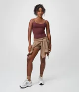 Bermuda deportiva femenina modelo runner de color tostado, con cintura elástica, aberturas laterales y pequeño bolsillo funcional trasero. Confeccionada en poliéster con elastano.