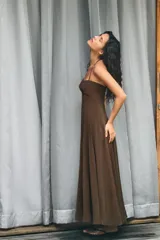 Vestido midi de corte fluido con cuello halter y lazada ajustable. Presenta escote recto y falda con volumen.