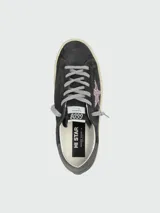 Championes Golden Goose modelo Hi Star, color gris oscuro con estrella glitter rosa, cordones grises y detalles en gris claro.