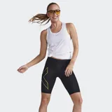 Short de compresión de tiro medio para mujer, color negro, con estampado texturizado y el logo grande de 2XU en amarillo dorado en el muslo izquierdo.