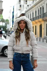 Campera puffer color beige, con capucha desmontable con borde de piel sintética, cierre frontal y bolsillos laterales.