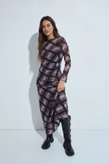 Falda larga de corte fluido con estampado de cuadros en tonos oscuros, rojizos y blancos. Presenta un diseño ligero con terminaciones onduladas en el ruedo.