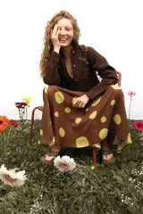 Falda larga de gasa con estampado de lunares grandes en tonos marrón y verde lima. Presenta un diseño de doble tela con caída fluida y cierre lateral oculto.