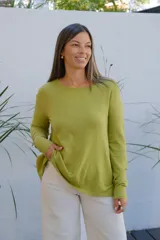 Sweater de punto color verde oliva, con cuello redondo, manga larga y corte holgado con ruedo asimétrico.