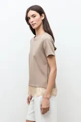Remera oversized color topo con detalle de encaje en el ruedo, de manga corta y cuello redondo.