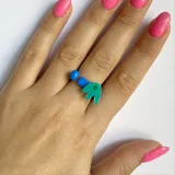 Anillo ajustable con apliques de plástico azul y verde.