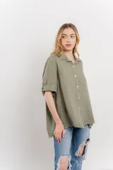 Camisa de lino color verde militar, de corte amplio y caída ligera. Cuenta con cuello camisero, botones en el frente y mangas 3/4 que se pueden arremangar.