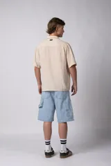 Camisa de manga corta confeccionada en lino, con cuello clásico y cierre frontal de botones. Presenta un corte relajado y textura liviana.