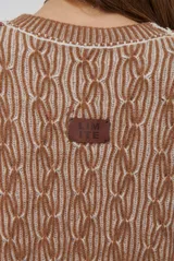 Buzo reversible de tejido de punto con diseño de trenzas, cuello redondo y mangas largas. Presenta una combinación de colores en contraste, con un lado en violeta y el otro en marrón oscuro.