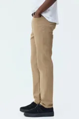Pantalón de sarga de algodón con diseño de cinco bolsillos, cierre frontal con botón y corte ajustado.
