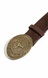 Cinto de gamuza marrón con hebilla metálica ovalada de estilo western, con relieve de cabeza de toro y leyenda grabada.