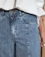 Pantalón de jean estilo wide leg con costuras verticales frontales, tiro alto y bolsillos laterales.