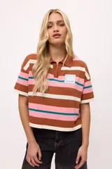 Remera tejida de algodón con cuello polo amarillo, corte boxy y estampado de rayas horizontales en tonos azul claro, marrón, rojo y amarillo.