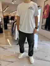 Remera blanca de manga corta con estampa frontal y de texto grande en la espalda que dice 'DON'T FOLLOW ME (I'M LOST TOO)' y la marca 'DUXON ORIGINAL'.