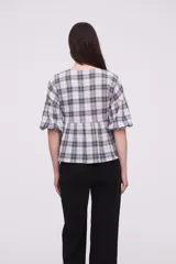 Blusa de algodón con estampado a cuadros, cuello en V, corte holgado y mangas cortas abullonadas con frunces.