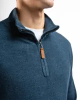 Buzo de tejido de punto negro, con cuello alto y cierre frontal parcial.