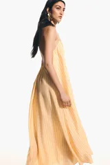 Vestido largo de corte holgado en tejido liviano, con diseño evasé, escote en V y breteles finos para atar en los hombros.