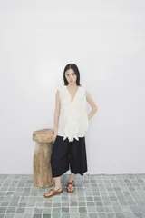 Sandalia plana color marrón con tiras de cuero y hebillas metálicas doradas.