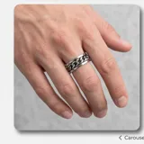 Anillo de acero italiano con diseño giratorio que presenta un motivo de cadena central.