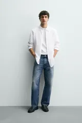 Camisa blanca de lino de corte regular fit, con cuello abotonado, manga larga y cierre frontal de botones.