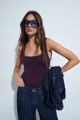 Body negro de escote cuadrado y silueta ajustada al cuerpo, sin mangas. Confeccionado en tejido de poliamida con elastano, de textura suave y elástica.