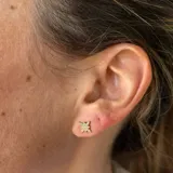 Aros pequeños con forma de estrella de ocho puntas, con acabado en oro de 18k y circonitas engarzadas.