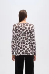 Sweater de punto con estampado floral en tonos rosados y marrones sobre base color crema, de cuello redondo y manga larga.