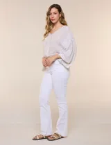 Blusa de algodón y rayón color beige, de la marca Dash. Presenta diseño texturado con sutiles rayas verticales, escote en V cruzado, mangas tres cuartos amplias y ruedo elastizado.