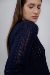Sweater azul marino de punto calado, confeccionado en 100% baby alpaca, de manga larga y cuello redondo.