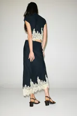 Falda midi azul marino con efecto arrugado y detalle de encaje en el ruedo. Cuenta con cintura elástica y forro interior.
