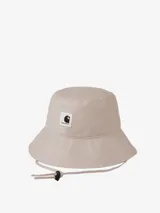 Sombrero tipo bucket Carhartt WIP modelo Ashley, color beige, confeccionado en sarga de algodón, con cordón ajustable y etiqueta cuadrada tejida con el logo en el frente.