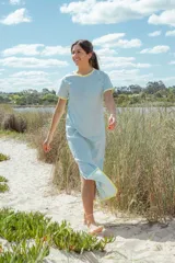 Vestido largo celeste con cuello redondo y mangas cortas con ribete amarillo.