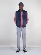 Chaleco acolchado azul marino confeccionado en nylon reciclado repelente al agua, con diseño slim fit, cremallera central y bolsillos laterales.