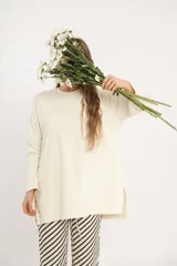 Remerón oversize de manga larga color crudo, con cuello redondo y aberturas laterales. Tejido de punto acanalado. Talle único.