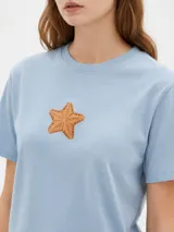 Remera cropped de algodón con cuello redondo, diseño holgado y estampado frontal de una copa con cerezas.