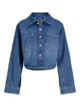 Sobrecamisa cropped de denim azul medio, con cuello clásico, mangas largas globo y dos bolsillos de parche con tapa en el pecho.