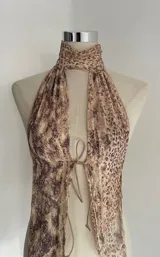 Top halter con estampado abstracto en tonos beige y marrón, con cuello alto y lazos ajustables en el frente.