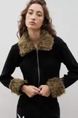 Saco tejido de algodón en color negro, con cierre frontal y detalles de piel sintética en cuello y puños.