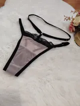 Pack de tres tangas tipo colaless confeccionadas en microtul y encaje, con tiras laterales regulables. El diseño presenta detalles de encaje en los bordes y transparencias.