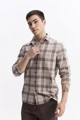 Camisa de manga larga confeccionada en viyela de algodón con diseño de cuadros en tonos azul y verde. Presenta cierre frontal con botones, cuello clásico y bolsillo en el pecho.