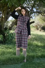 Falda midi de corte recto confeccionada en tejido de lana con estampado de cuadros en tonos tierra y líneas en contraste. Presenta un diseño estructurado con forro interior.