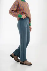 Pantalón de tejido de punto en color azul grisáceo, de corte recto y tiro alto, con detalle de costuras verticales que estilizan la silueta.