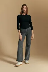 Remera blanca de manga larga con tejido acanalado, cuello redondo y corte ajustado al cuerpo. Presenta costuras verticales que definen la silueta.