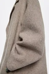 Chaquetón corto de corte recto confeccionado en lana doble faz, con doble botonadura frontal, cuello con solapa y manga larga. Presenta bolsillos en costura y barbuquejo en el cuello.