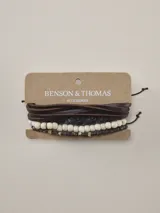 Pulsera Benson & Thomas modelo Lieja, diseño multicapa compuesto por tiras de cuero marrón, una tira trenzada y hileras de cuentas de madera en tonos claros y oscuros.